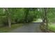 Road leading to this condo surrounded by lush greenery with a few openings to a green lawn, trees, and surrounding nature at 500 Umstead Dr # 105D, Chapel Hill, NC 27516