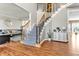 Bright foyer featuring hardwood floors, staircase with iron railing, and open access to the living room at 505 Redford Place Dr, Rolesville, NC 27571