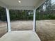 Covered back porch with a view of the expansive backyard, framed by natural surroundings at 6814 Galloway Dr, Middlesex, NC 27557