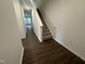 Hallway with hardwood floors leads to carpeted stairs, enhancing the home's modern design at 6814 Galloway Dr, Middlesex, NC 27557