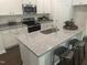 Well-lit kitchen island with seating, granite countertop, stainless steel appliances, and white cabinets at 6814 Galloway Dr, Middlesex, NC 27557