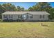 Charming single-story home with a well-manicured lawn, complemented by mature trees and an American flag at 7850 Nc 42, Holly Springs, NC 27540