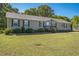 Cozy single-story home with a well-kept lawn, enhanced by neatly trimmed shrubs and a vibrant American flag at 7850 Nc 42, Holly Springs, NC 27540
