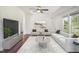 Bright living room with ceiling fan, a large TV, modern seating arrangement, and hardwood floors at 7850 Nc 42, Holly Springs, NC 27540