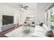 Inviting living room with ceiling fan, a large TV, modern seating arrangement, and hardwood floors at 7850 Nc 42, Holly Springs, NC 27540