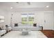 Bright living room featuring modern white furniture, hardwood floors, and plenty of natural light at 7850 Nc 42, Holly Springs, NC 27540