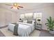 Spacious primary bedroom with a ceiling fan, plush bedding and two windows for ample natural light at 7850 Nc 42, Holly Springs, NC 27540