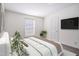 Light primary bedroom with plush bedding, a TV and one window for natural light at 7850 Nc 42, Holly Springs, NC 27540