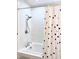 Bathroom featuring a polka-dot shower curtain, tiled shower, and chrome fixtures at 811 S First St, Smithfield, NC 27577