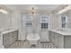 Bright bathroom with standalone tub, dual sinks, patterned rug, and modern light fixtures at 811 S First St, Smithfield, NC 27577