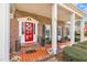 Welcoming front porch with brick flooring, rocking chairs, a red door, and manicured landscaping at 811 S First St, Smithfield, NC 27577