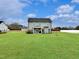 The backyard features a lush green lawn, a covered patio, and a view of the home's exterior at 897 W Main St, Benson, NC 27504