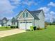 Side view of home with a basketball hoop, two-car garage, and well-kept lawn at 897 W Main St, Benson, NC 27504