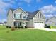 Beautiful two-story home with a well-maintained lawn, a covered porch and attached garage at 897 W Main St, Benson, NC 27504