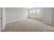 Bright, carpeted bedroom with a large window, offering natural light and neutral tones at 92 Ripple Way # 315, Clayton, NC 27520