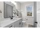 Bathroom boasts a modern vanity with a sleek countertop, matte fixtures and bright natural light at 955 Lynch Rd, Selma, NC 27576