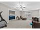 Large, carpeted bonus room featuring neutral walls, a ceiling fan, and a comfortable seating area for relaxation at 955 Lynch Rd, Selma, NC 27576