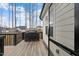 Back deck perfect for outdoor relaxation, featuring wood flooring, black railings, and a grill at 955 Lynch Rd, Selma, NC 27576