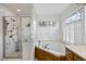 Inviting bathroom with a soaking tub, glass shower, and a bright window at 1 Nicklaus Way, Clayton, NC 27520