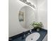 Stylish powder room featuring a round mirror, modern vanity, and sleek fixtures at 1 Nicklaus Way, Clayton, NC 27520