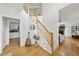 Inviting home entryway with wood floors, a staircase, and a view into the living room at 1 Nicklaus Way, Clayton, NC 27520