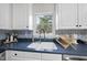 Bright kitchen with a stainless steel sink, and white cabinetry and backsplash at 1 Nicklaus Way, Clayton, NC 27520