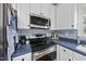 Close-up of a kitchen with stainless steel appliances and blue backsplash, well organized at 1 Nicklaus Way, Clayton, NC 27520