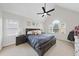 Spacious primary bedroom featuring a ceiling fan, windows, and a comfortable king-sized bed at 1 Nicklaus Way, Clayton, NC 27520