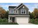 Charming two-story home with gray siding, a two-car garage, and manicured landscaping at 10068 Regal Dr, Angier, NC 27501