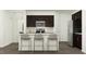 Modern kitchen featuring an island with seating, dark cabinetry, and stainless-steel appliances at 10068 Regal Dr, Angier, NC 27501