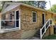 Brick home featuring a classic design, black door and trim, and a charming front porch with white railings at 105 Johnson St, Chapel Hill, NC 27516