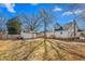 Backyard with white house, storage shed, fence and large trees at 1127 W Webb Ave, Burlington, NC 27217