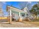 Home showcasing covered front porch supported by brick columns and inviting seating area at 1127 W Webb Ave, Burlington, NC 27217