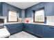 Bright kitchen with white countertops, stylish blue cabinets, brass hardware, and stainless steel appliances at 1127 W Webb Ave, Burlington, NC 27217