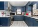 Updated kitchen featuring stylish blue cabinets, white countertops, and modern stainless steel appliances at 1127 W Webb Ave, Burlington, NC 27217