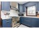 Well-lit kitchen featuring blue cabinets, white countertops, and modern stainless steel appliances at 1127 W Webb Ave, Burlington, NC 27217