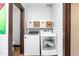 Clean laundry room with washer, dryer, white shelves, and white walls at 1127 W Webb Ave, Burlington, NC 27217