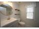 Well-lit bathroom with single sink vanity, toilet and window, with open shelving at 113 Hawkscrest Ct, Apex, NC 27502
