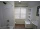 Bright bathroom with white fixtures, tiled floors, and a large window allowing natural light at 113 Hawkscrest Ct, Apex, NC 27502