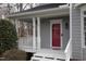 Inviting front porch area with white columns and a red front door at 113 Hawkscrest Ct, Apex, NC 27502