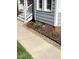 Close-up of the home's landscaping with colorful flowers, mulch, and stonework at 113 Hawkscrest Ct, Apex, NC 27502