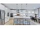 Modern kitchen boasts an island with bar seating, stainless appliances, and sleek white cabinets at 1133 Sun Springs Rd, Wake Forest, NC 27587