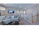 Upstairs living room featuring a comfortable couch, mounted television, and staircase at 1133 Sun Springs Rd, Wake Forest, NC 27587