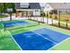 Community pickleball court featuring a net and blue surface surrounded by a black fence at 1133 Sun Springs Rd, Wake Forest, NC 27587