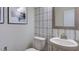 Stylish powder room with patterned wallpaper, pedestal sink, and decorative mirror at 1133 Sun Springs Rd, Wake Forest, NC 27587