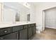 Bathroom with double sink vanity, neutral tiling and an attached closet space with shelving at 1794 Parham Dr, Graham, NC 27253