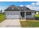 Charming home with a two-car garage, gray siding, and a cozy front porch at 1794 Parham Dr, Graham, NC 27253