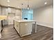 Well-lit kitchen showcases a center island, stainless steel appliances, and gray wood-look floors at 1794 Parham Dr, Graham, NC 27253