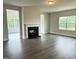 Cozy living room with fireplace, large windows, and wood-look floors, creating a warm ambiance at 1794 Parham Dr, Graham, NC 27253