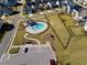 Aerial view showcasing a community pool, playground, and parking area within a residential neighborhood at 204 Woodstaff Ave, Wake Forest, NC 27587